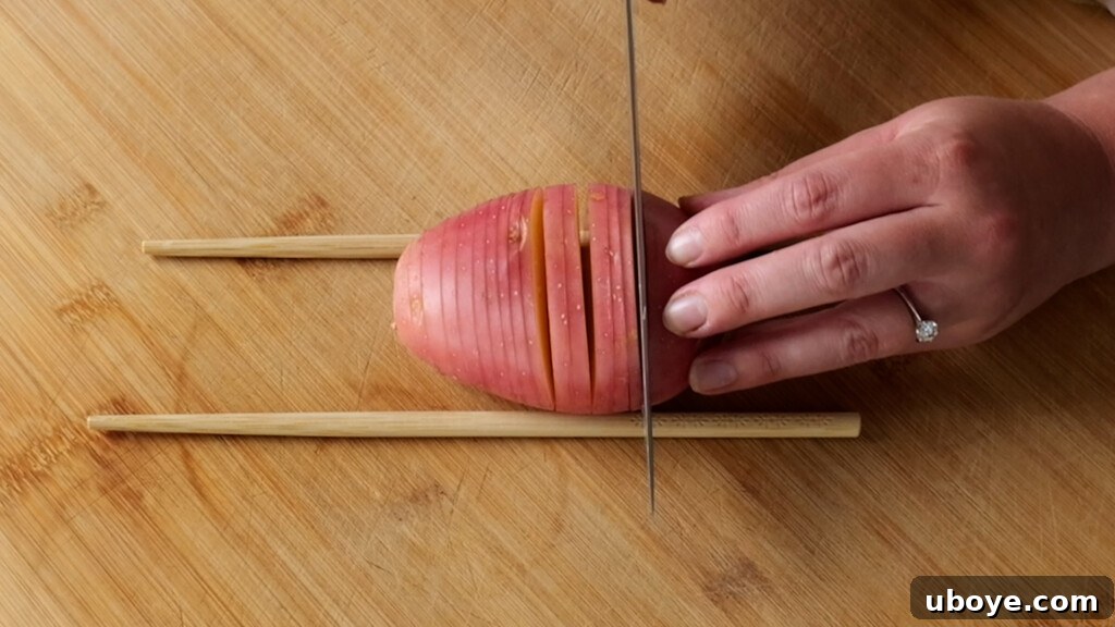 Step-by-step image of a potato being sliced between two chopsticks