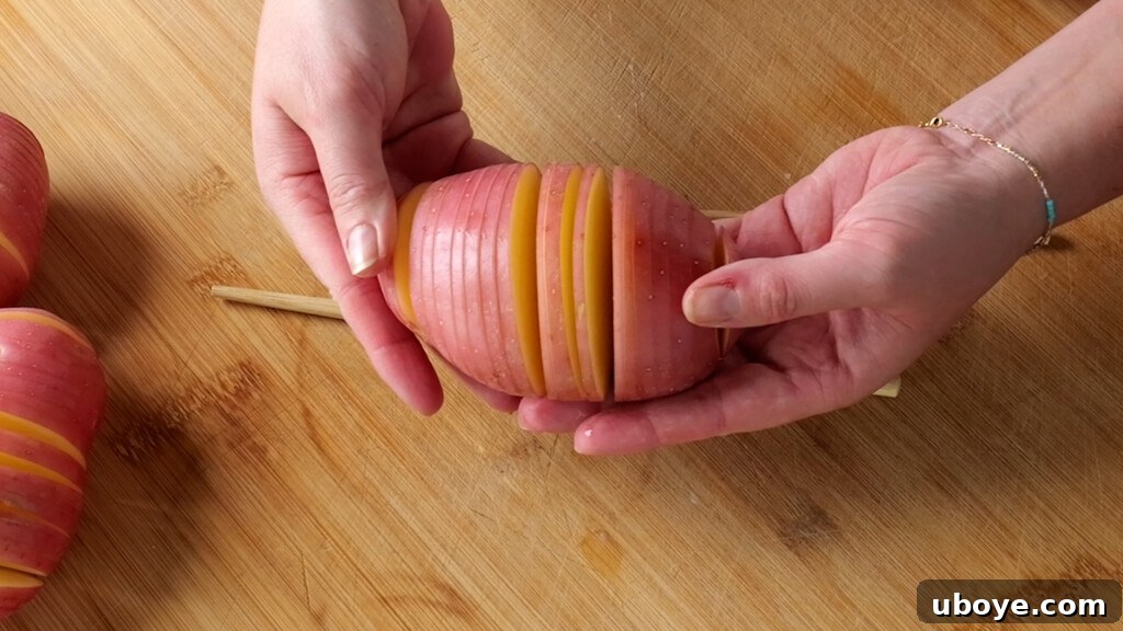 Close-up of a perfectly sliced hasselback potato, showing the accordion cuts