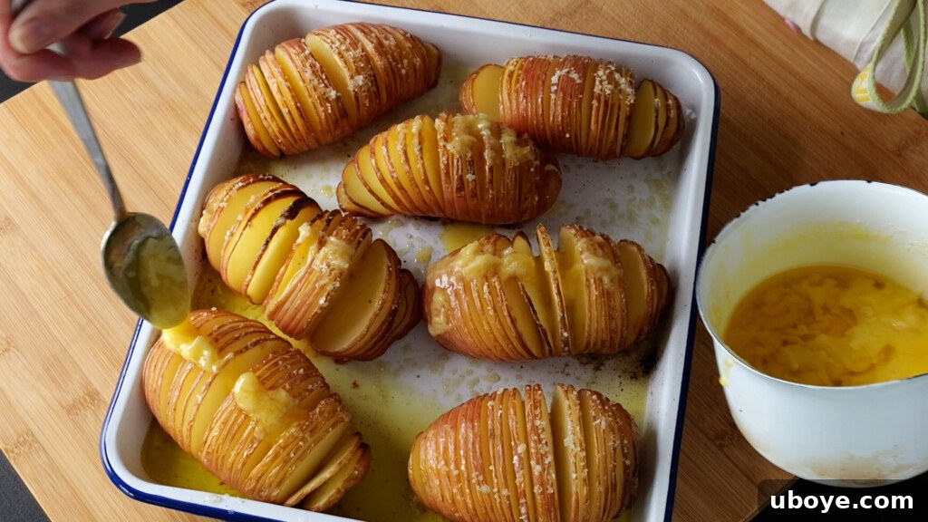 Basting hasselback potatoes with garlic butter during the second bake