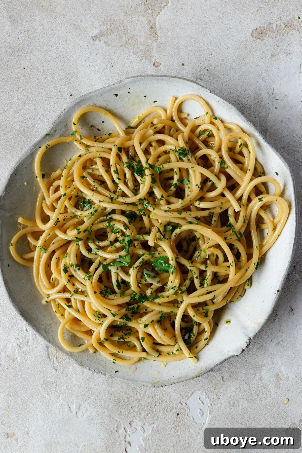 Decadent 10-Minute Anchovy Butter Pasta 2 A large white bowl of anchovy butter pasta, generously sprinkled with fresh parsley, ready to be served.